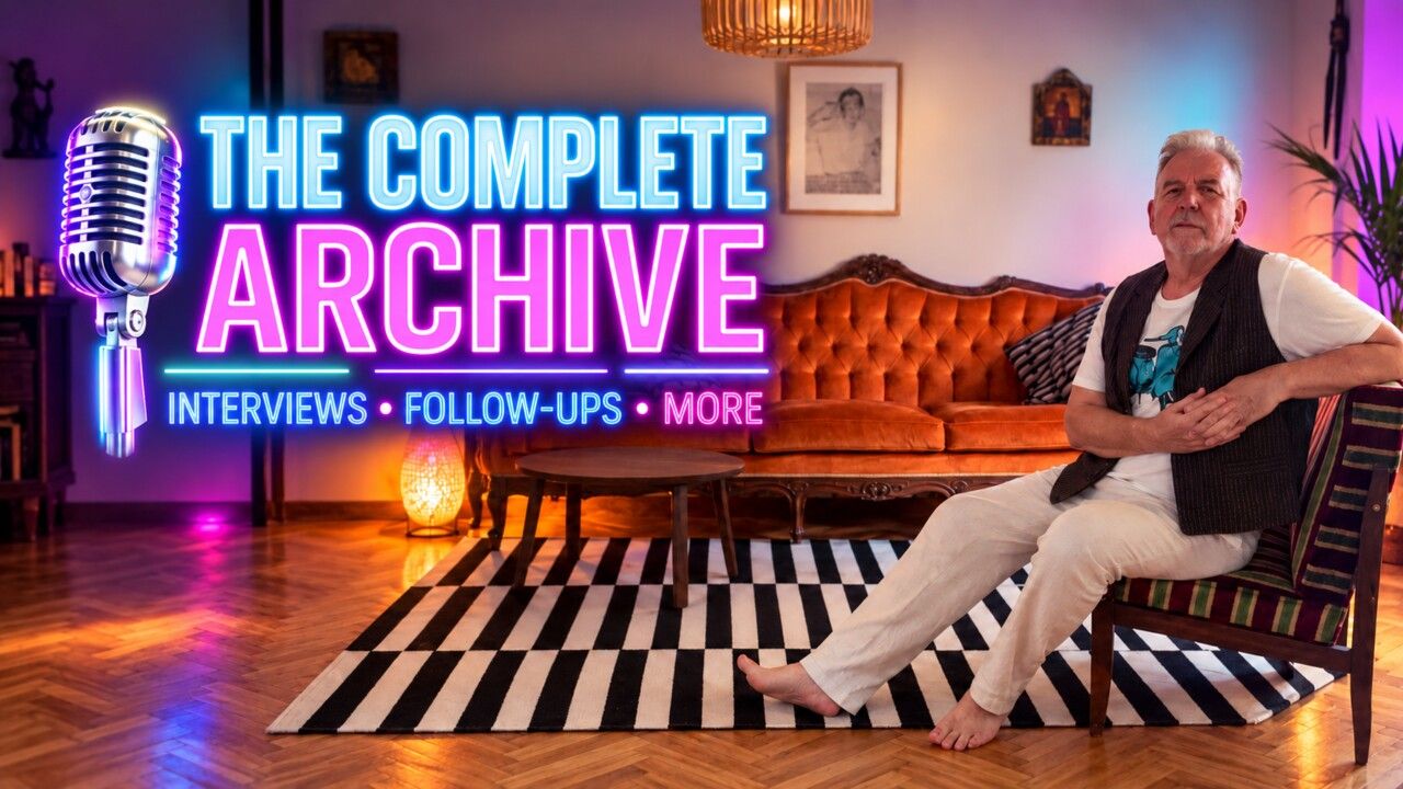 Steve Blame seated on a leather sofa beside a neon sign reading The Complete Archive